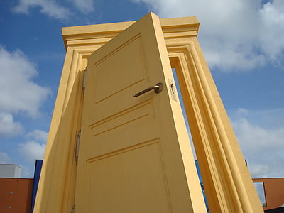 yellow wooden door under cloudy sky during daytime thumbnail