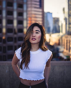 woman in white crop top standing on rooftop posing for photo during daytime thumbnail