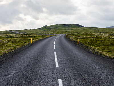 empty asphalt road with green fields and mountain as background photo thumbnail