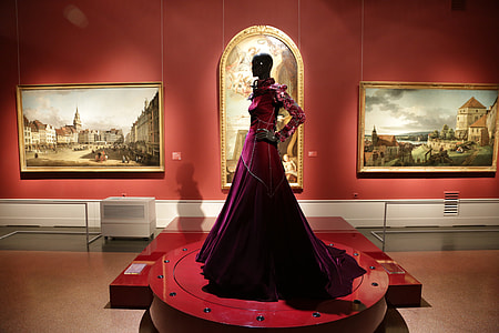 woman in maroon traditional dress standing on stage thumbnail