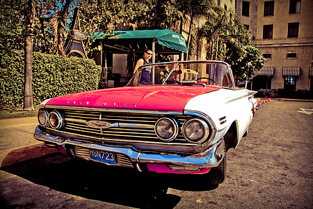 red and white coupe parked beside parking curb thumbnail