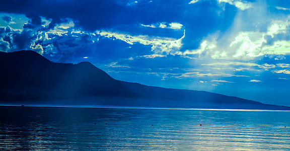 Silhouette of Mountain Near Water at Daytime thumbnail