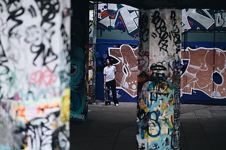 man standing next to wall graffiti thumbnail