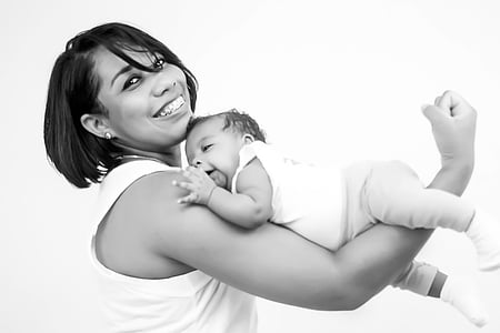 grayscale photo of woman carrying baby with her arm thumbnail