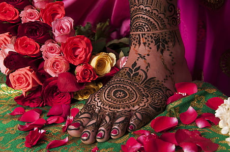 person with foot tattoo standing beside roses thumbnail