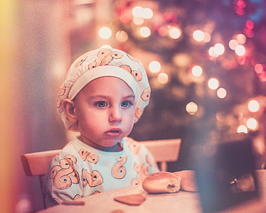 toddler sitting on chair beside bread on table thumbnail