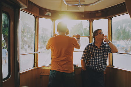 two men standing inside the tram at daytime thumbnail