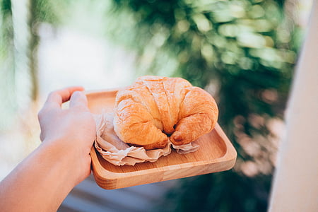person holding square brown tray with bake bread thumbnail