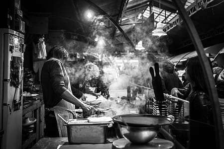 grayscale photo of person cooking food in kichine thumbnail