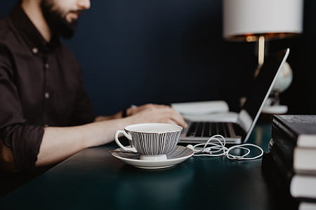 Male working with a laptop and a cup of coffee thumbnail