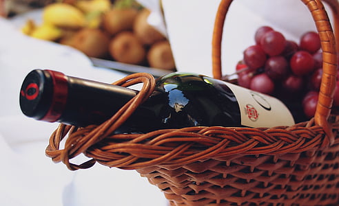 close-up photo of wine bottle with grapes on brown wicker basket thumbnail