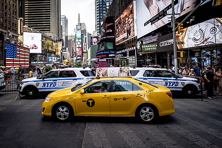yellow sedan crossing on road at daytime thumbnail