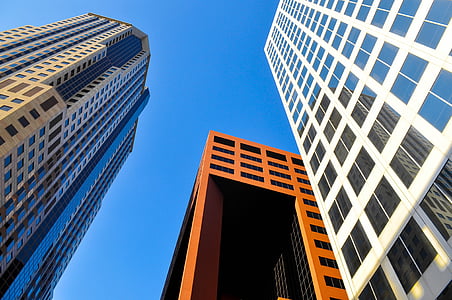 low angle photography of brown and white concrete buildings during daytime thumbnail