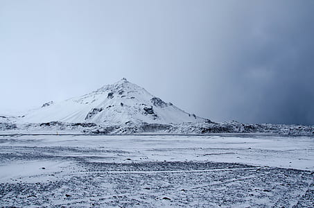 landscape photography of snow hill under cloudy sky thumbnail