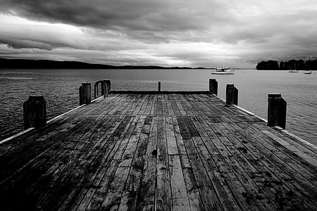 grayscale photography of dock bridge near ocean thumbnail