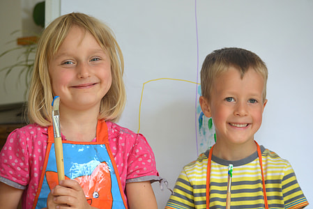 girl and boy in front of white easel while taking selfie thumbnail