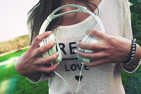 woman holding white corded headphones thumbnail