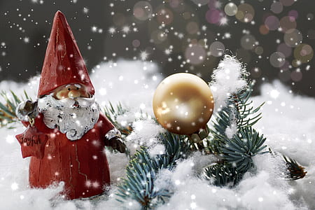 Santa Claus figure on snowfield beside gold-colored ornament thumbnail