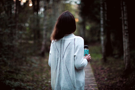 Girl in white shirt walking in the woods thumbnail