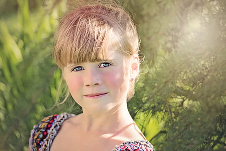 girl standing beside green leafed plant thumbnail