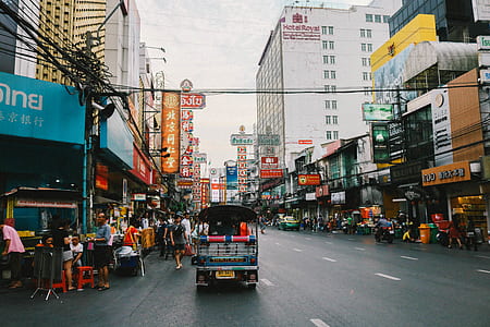 blue auto-rickshaw passing through buildings thumbnail