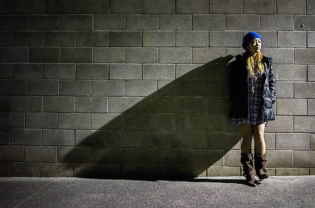 woman wearing black jacket lying on gray wall thumbnail