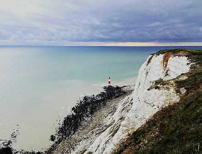 lighthouse on cliff overlooking sea at daytime thumbnail