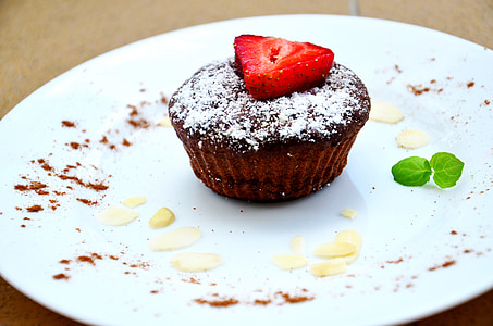 chocolate cupcake with strawberry top on white ceramic plate thumbnail