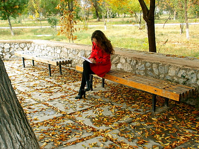 woman in red coat sitting on a bench thumbnail