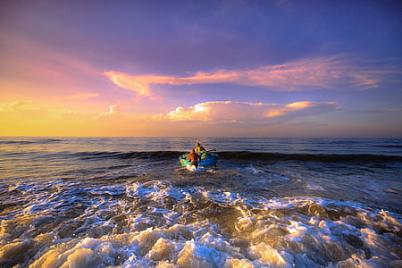 person sailing boat during yellow sunset thumbnail
