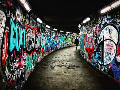person walking through graffiti tunnel thumbnail