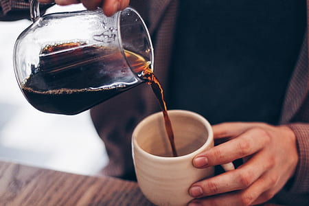photo of person holding pitcher filled with liquid pouring into cup thumbnail