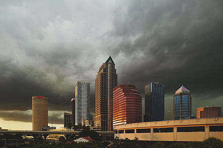 architectural photography of cityscape surrounded with dark clouds thumbnail