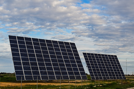 two reclining solar panels on field under white clouds taken during daytime thumbnail