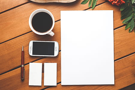 high angle photo of white paper, white Samsung Galaxy Android smartphone, white ceramic mug filled with tea, red fountain pen and two white mini papers thumbnail