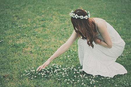 woman in white gown picking flower on greenfield thumbnail