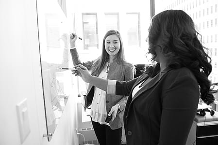 Two Smiling Woman Writing on Board thumbnail