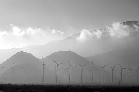 windmills near mountain under white sky thumbnail