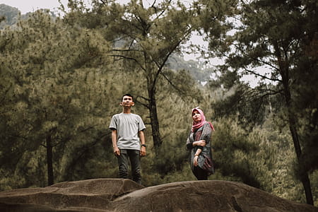 Man And Woman Standing Near Pine Trees thumbnail