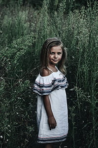 girl standing surrounded by plants thumbnail