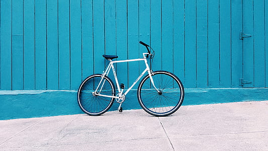white road bike beside blue painted wall thumbnail