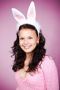 smiling woman with bunny headband and pink v-neck knit sweater\ thumbnail