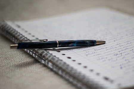black retractable pen on spiral notebook thumbnail