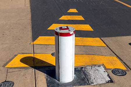 white vehicle stopper post on concrete road thumbnail