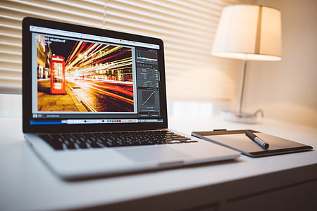 black laptop computer beside white table lamp turned on thumbnail