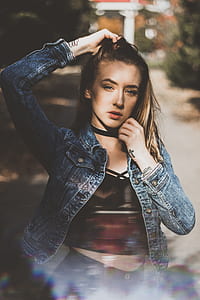 woman standing holding her hair between trees thumbnail
