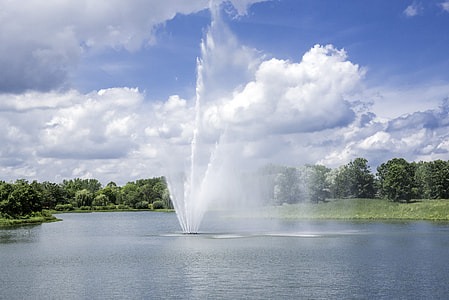 Fountains in the pool under blue sky and clouds at the Chicago Botanical Gardens thumbnail
