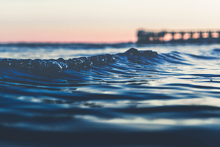 selective photo of ocean wave with background of dock thumbnail