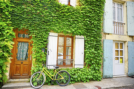 closeup photography of yellow step through frame bike parked on door's window thumbnail