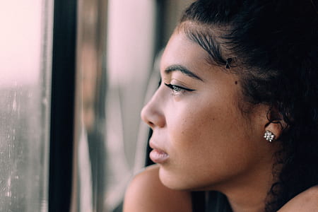 woman looking in front of clear glass window during daytime thumbnail